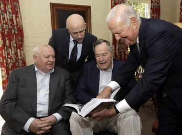 Former Secretary of State James Baker, right, points out a page in former President of the Soviet Union Mikhail Gorbachev's, left, book to former President George H.W. Bush, center, before their lunch Thursday, Nov. 1, 2012, in Houston. © AP